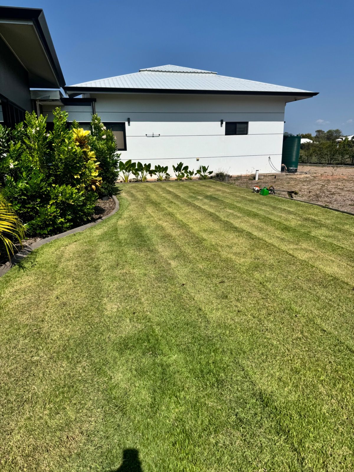 Completed landscaped outdoor area in Muirhead NT with greenery and tidy garden features after work