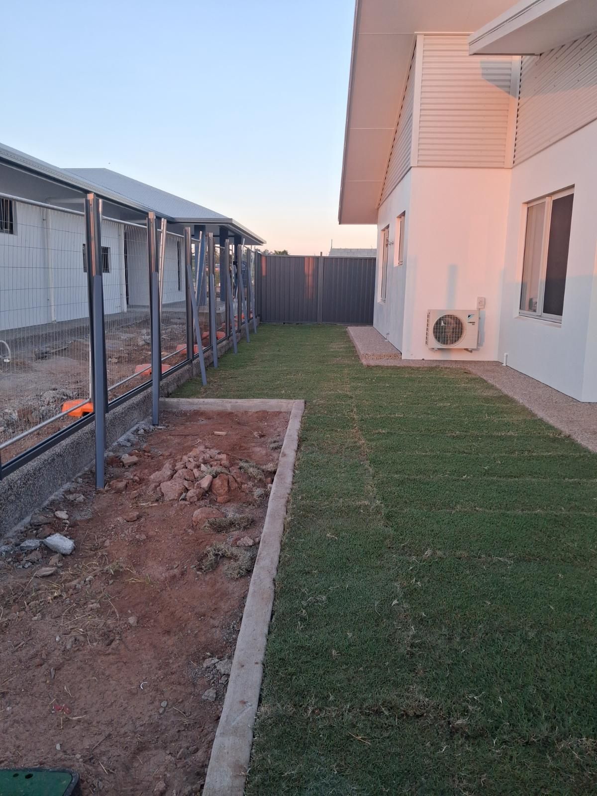Fresh green lawn installed next to a white modern house with air conditioning unit at Marrara Gardens NT.
