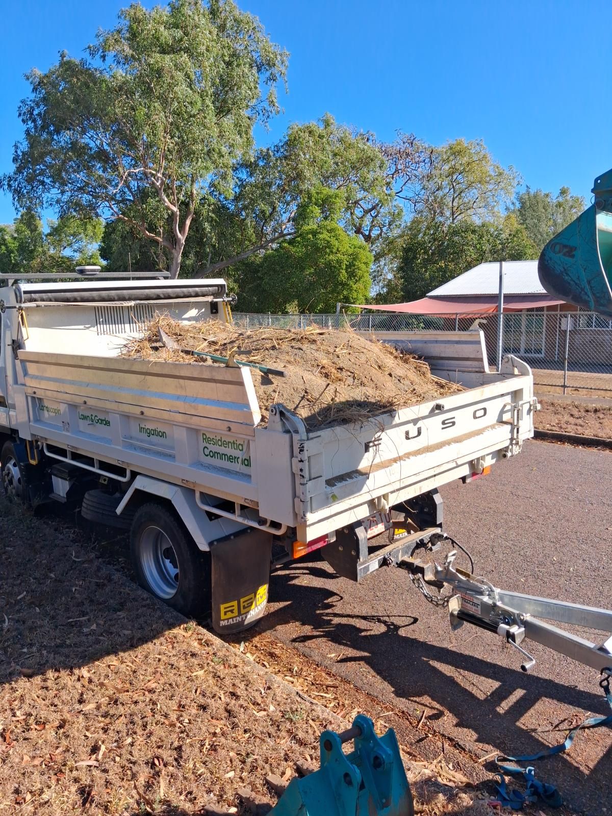 White truck loaded with landscaping debris parked on roadside after garden waste removal service in Tiwi Northern Territory.